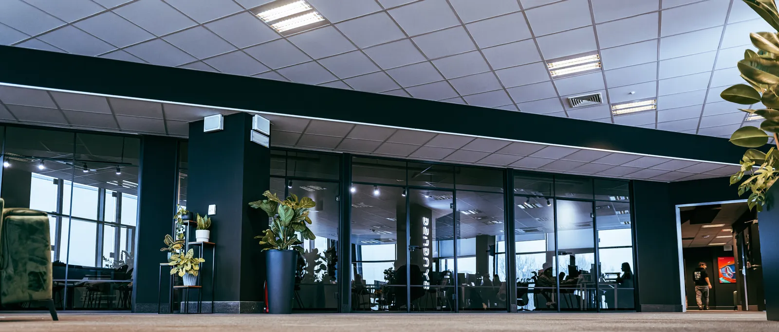 Kraków HQ — office lobby with glass-walled workspaces